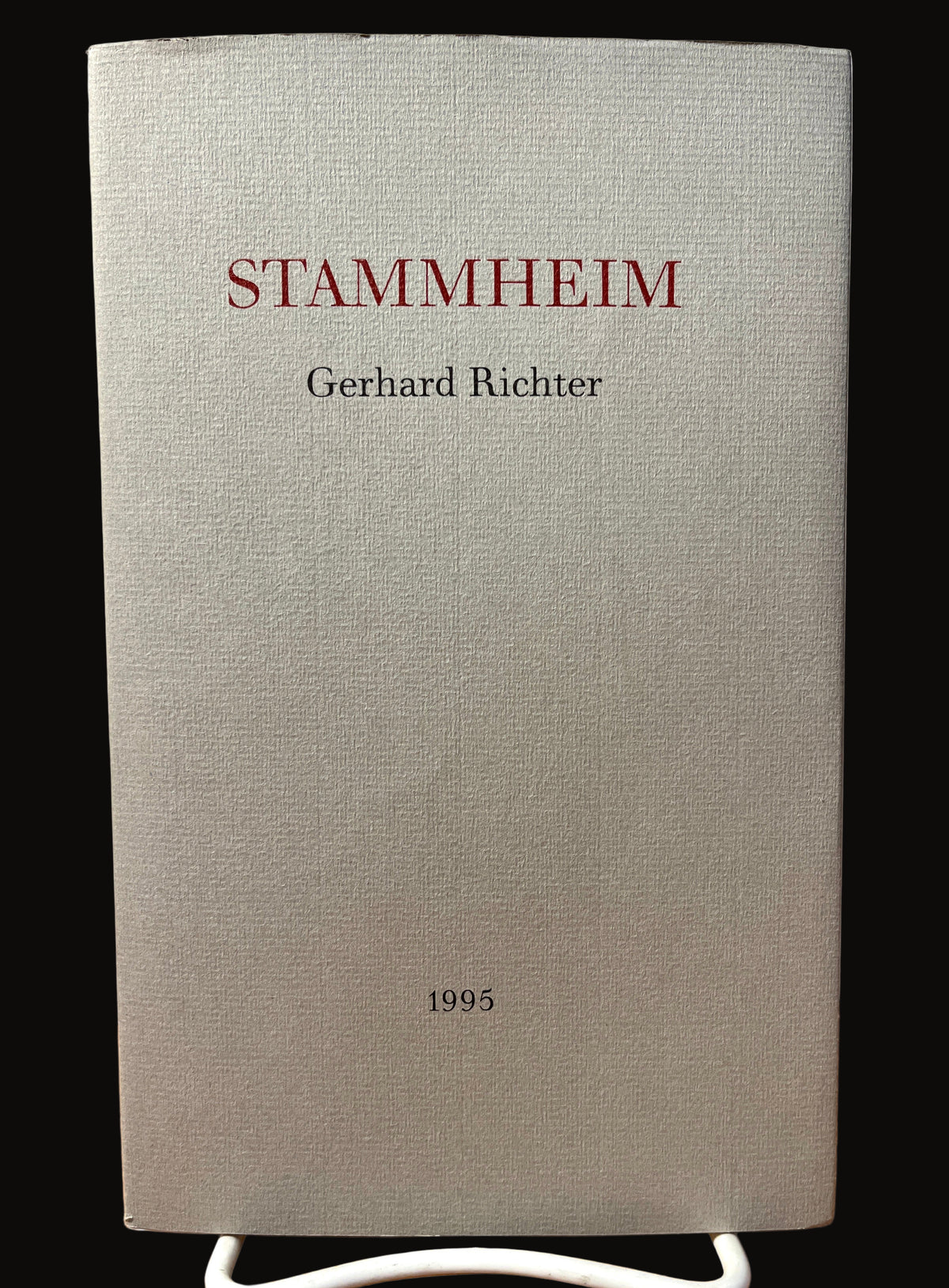 The image shows the cover of an artist book titled 'Stammheim' by Gerhard Richter, published by Anthony d'Offay Gallery in 1995. The cover is in a neutral gray tone with red and black text, featuring the title and the artist's name.