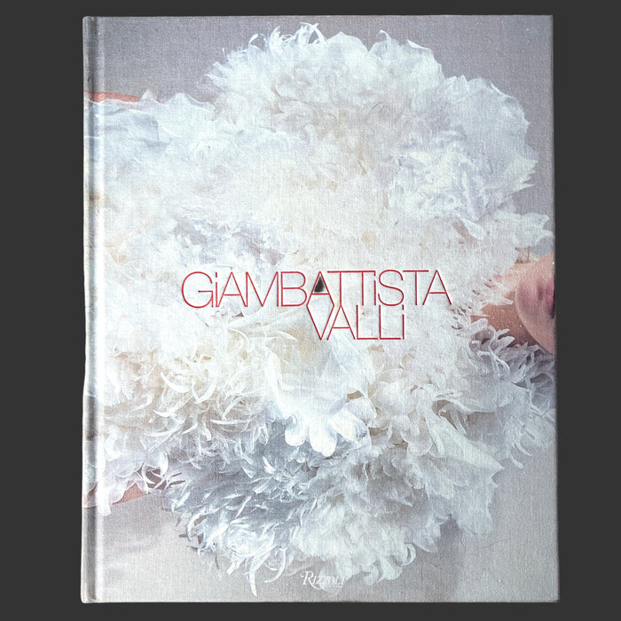 The cover of the book 'Giambattista Valli' featuring a monochrome photograph of a white, feathery-textured garment, with the title 'GIAMBATTISTA VALLI' prominently displayed.